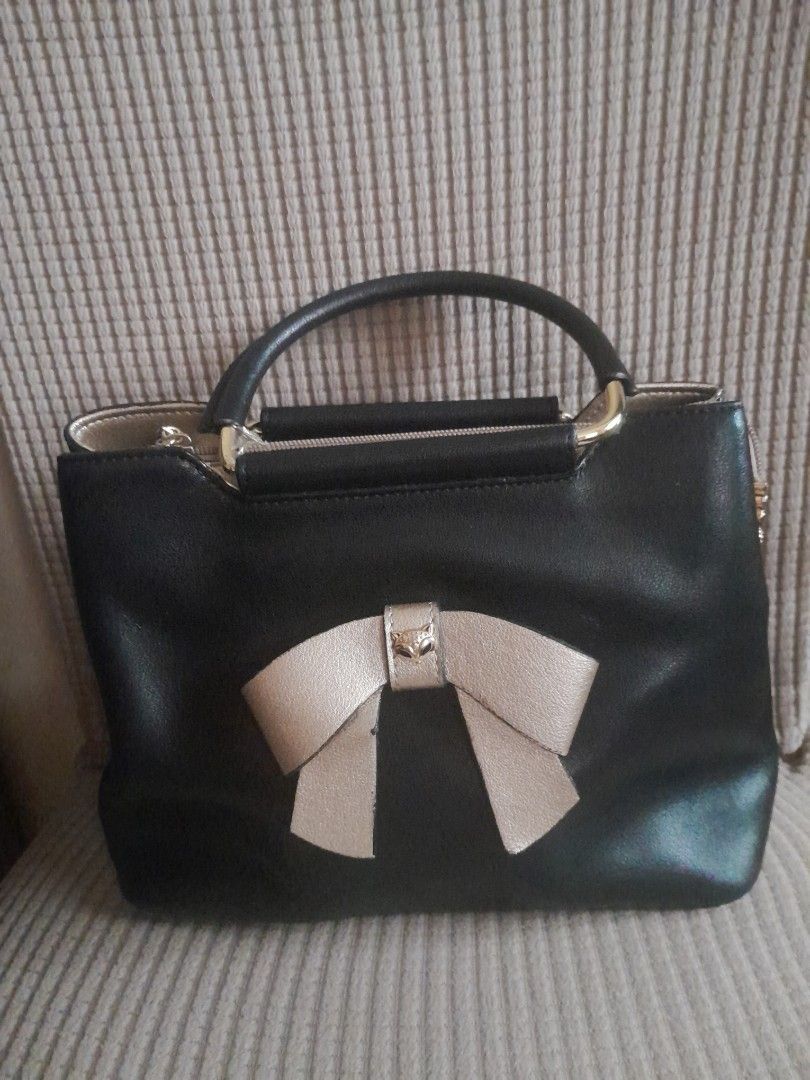 Foxer Black Handbag with Bow Detail (Category: Luxury Bags & Wallets) located in Quezon City. Submitted by lalaine.r (Listing ID 1421952012, Image 1). Description: - Foxer black handbag - Stylish bow detail - Top handle - Back zippered pocket - Spacious interior with small inner pocket - Gold-toned hardware - Structured design - Perfect for everyday or special occasions - Issue: Missing Sling.