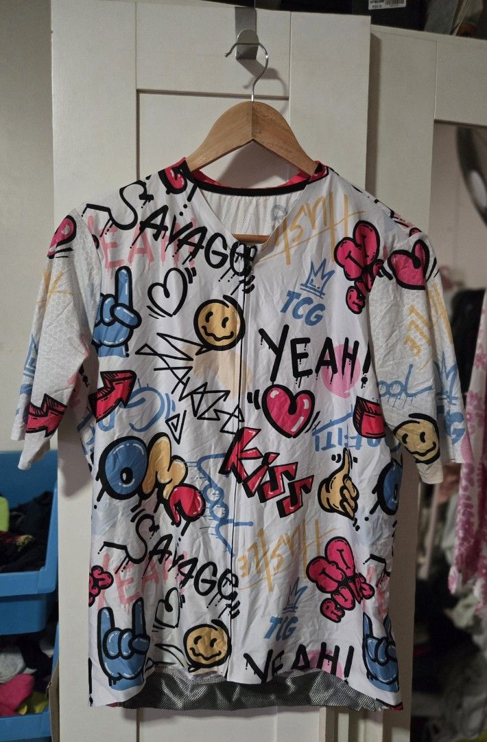 Graphic Print Jersey (Category: Activewear) located in Quezon City. Submitted by ddlry (Listing ID 1422003786, Image 1). Description: - White jersey - Full-length zipper - Short sleeves - Colorful graphic print with "SAVAGE", "YEAH!", and "KISS" - Pink back pocket area - Black collar trim.