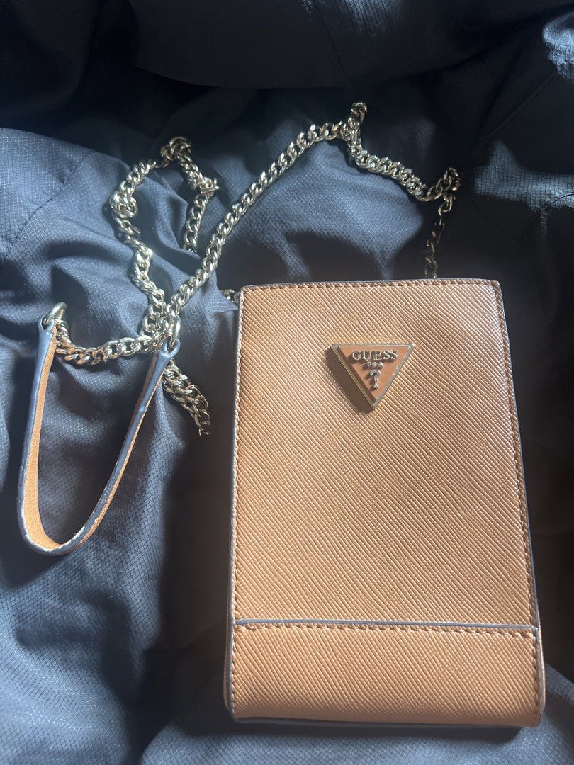 Guess Phone Sling Bag (Category: Cross-body Bags) located in Taguig. Submitted by stuffitlikeitshot (Listing ID 1421958642, Image 1). Description: - Guess phone bag with gold chain strap - Brown color with Guess logo - Multiple compartments for cards and small items - Convenient chain strap for carrying - Used for an event only.