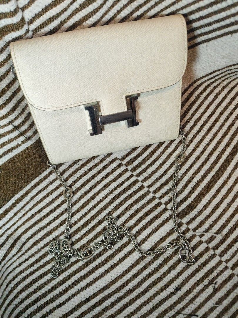 Hermes Style Shoulder Bag with Chain (Category: Luxury Bags & Wallets) located in Paranaque City. Submitted by shopnsaveph (Listing ID 1422071704, Image 1). Description: - Cream-colored shoulder bag - Silver chain strap - Silver 'H' flap closure - Includes orange Hermes shopping bag - Stylish and elegant design - Suitable for various occasions.