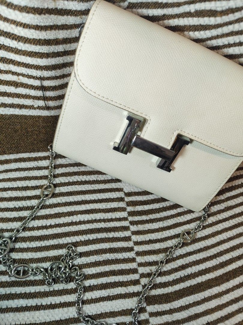 Hermes Style Shoulder Bag with Chain (Category: Luxury Bags & Wallets) located in Paranaque City. Submitted by shopnsaveph (Listing ID 1422071704, Image 2). Description: - Cream-colored shoulder bag - Silver chain strap - Silver 'H' flap closure - Includes orange Hermes shopping bag - Stylish and elegant design - Suitable for various occasions.