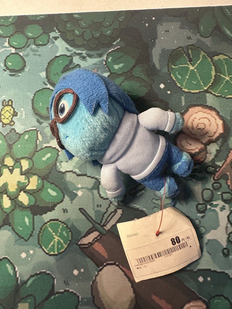 Inside Out Sadness Charm As Is (Category: Plushies & Soft Toys) located in Manila. Submitted by rumiiiiiiiii (Listing ID 1421981542, Image 2). Description: - Inside Out Sadness plush toy - Features Sadness in blue with glasses and white sweater - Includes original tag - Perfect for Inside Out fans and collectors.