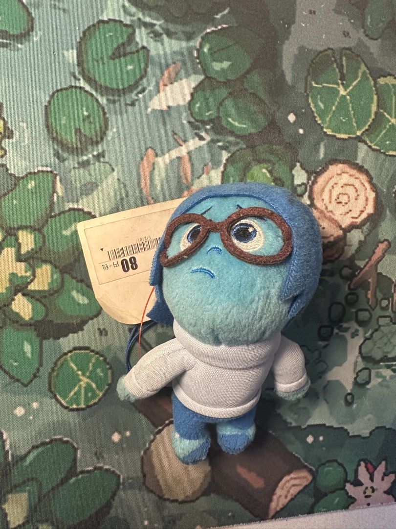 Inside Out Sadness Charm As Is (Category: Plushies & Soft Toys) located in Manila. Submitted by rumiiiiiiiii (Listing ID 1421981542, Image 1). Description: - Inside Out Sadness plush toy - Features Sadness in blue with glasses and white sweater - Includes original tag - Perfect for Inside Out fans and collectors.