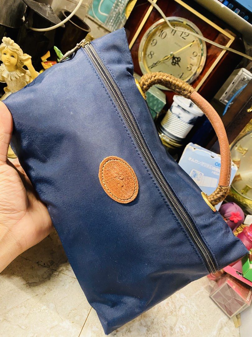 Longchamp Vanity Handbag with Handle (Category: Luxury Bags & Wallets) located in Bacolod City. Submitted by jeffreyhue19895 (Listing ID 1421979320, Image 1). Description: - Authentic Longchamp handbag - Color: Navy blue - Top zipper closure - Brown leather handle with woven detail - Leather patch with logo - Zipper pull engraved with "Longchamp" and "FRANCE" - Material: Durable nylon.