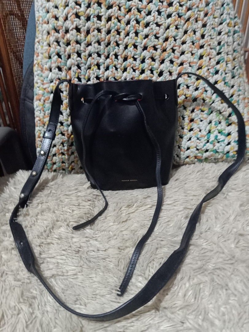 Mansur Gavriel Mini Bucket Bag (Category: Luxury Bags & Wallets) located in Cebu City. Submitted by lumaynojes00490 (Listing ID 1422047128, Image 3). Description: - Mansur Gavriel Mini Bucket Bag - Black leather exterior - Vibrant red interior - Drawstring closure - Detachable and adjustable shoulder strap - Made in Italy - 'Mansur Gavriel' branding on front.