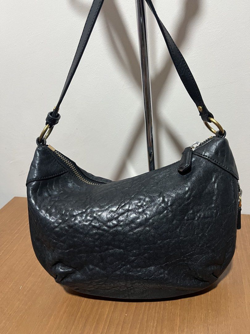 Marc by Marc Jacobs Black Shoulder Bag (Category: Luxury Bags & Wallets) located in Tarlac. Submitted by jclections (Listing ID 1422059784, Image 3). Description: - Marc by Marc Jacobs shoulder bag - Black, curved design - Zip closure - Gold-toned metal logo plate - Shoulder strap - Interior zip pocket - Textured leather.