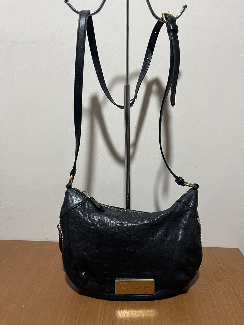 Marc by Marc Jacobs Black Shoulder Bag (Category: Luxury Bags & Wallets) located in Tarlac. Submitted by jclections (Listing ID 1422059784, Image 1). Description: - Marc by Marc Jacobs shoulder bag - Black, curved design - Zip closure - Gold-toned metal logo plate - Shoulder strap - Interior zip pocket - Textured leather.
