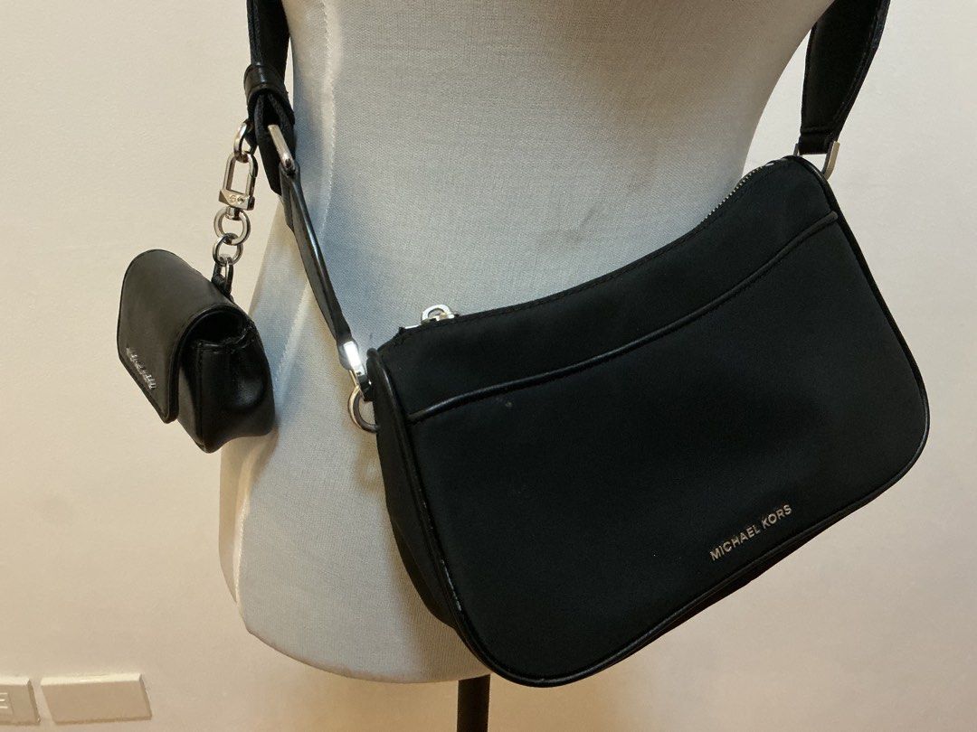 Michael Kors Black Crossbody Bag (Category: Luxury Bags & Wallets) located in Caloocan City. Submitted by mandagerma60728 (Listing ID 1422006990, Image 2). Description: - Michael Kors crossbody bag - Main compartment - Small attached pouch - Adjustable long strap - Silver Michael Kors logo - Made of a nylon-like material.