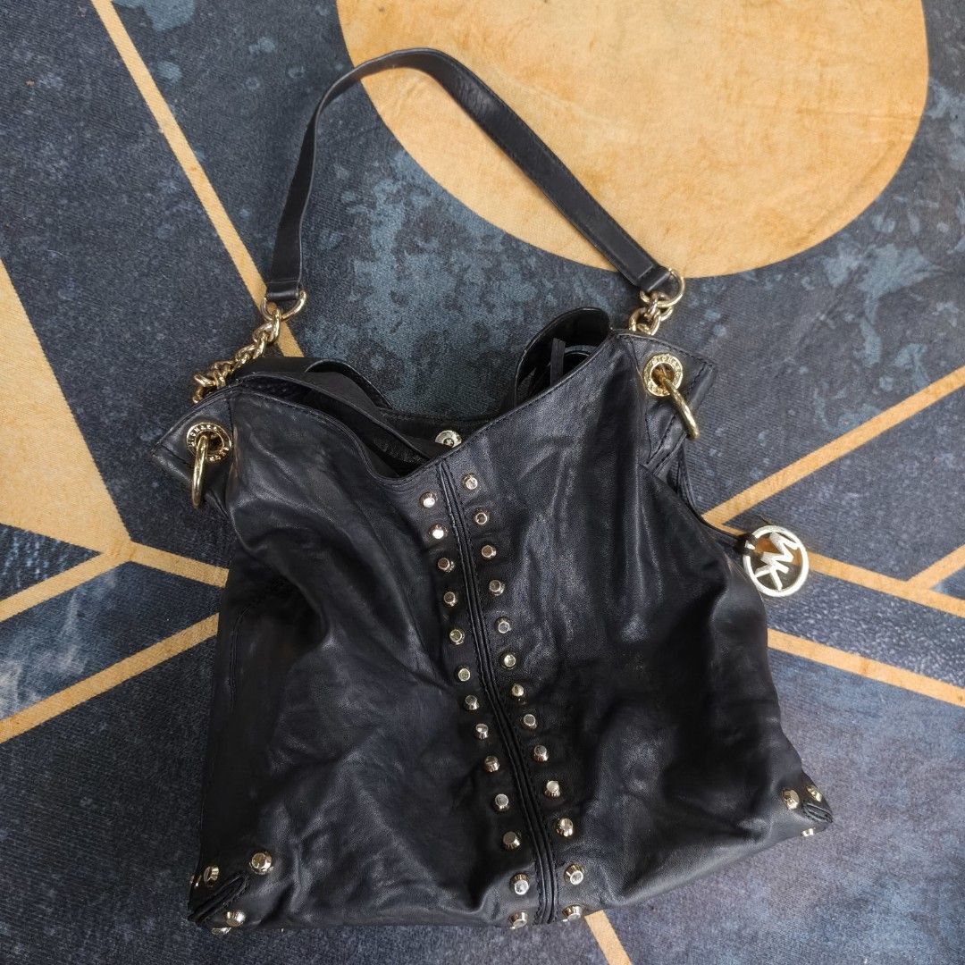 Michael Kors Uptown Astor Studded Tote (Category: Luxury Bags & Wallets) located in Bayombong. Submitted by easyflip_04 (Listing ID 1422006836, Image 1). Description: Black Michael Kors Uptown Astor shoulder bag. Features gold-tone studs and hardware. Includes a top handle and a shoulder strap. The interior has a patterned lining and a small tag. The bag has a Michael Kors logo charm..
