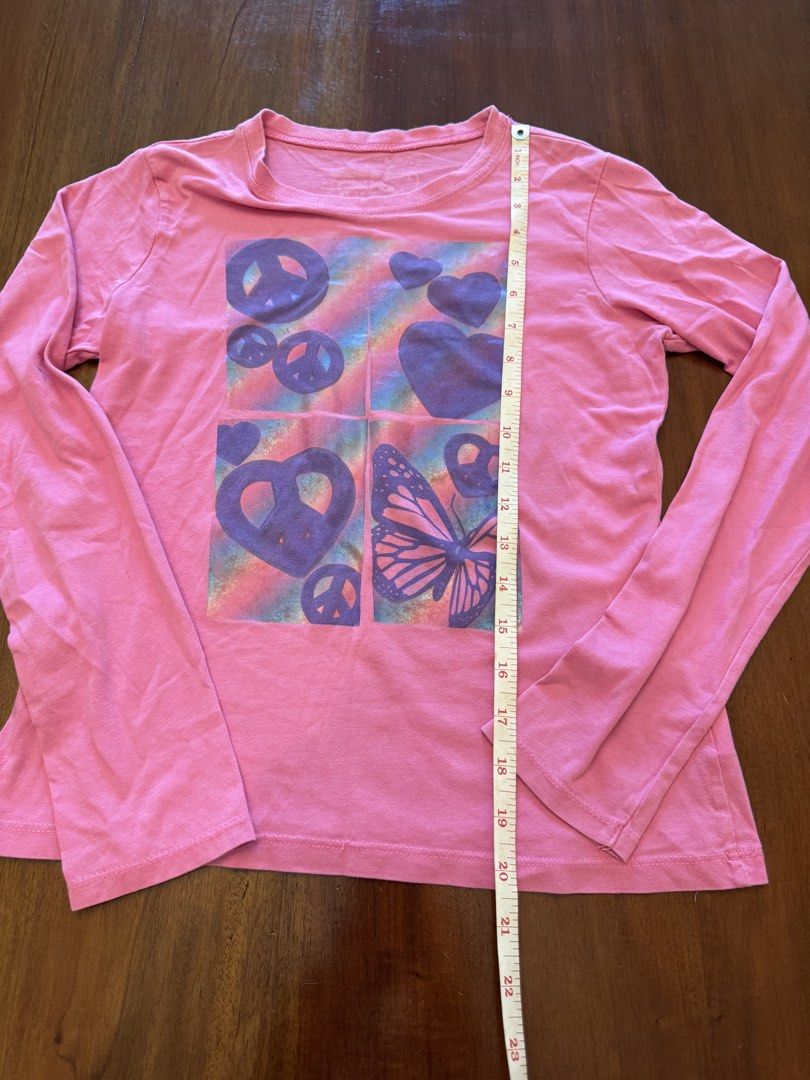 My Perfect Tee Long Sleeve Shirt (Category: Tshirts & Polo Shirts ) located in Mandaue City. Submitted by marginiz (Listing ID 1421954706, Image 3). Description: Pink long-sleeved shirt with a colorful graphic print. The print features peace signs, hearts, and a butterfly. The shirt has a round neckline. The size is XL 14. The shirt is made of a soft material, perfect for everyday wear..