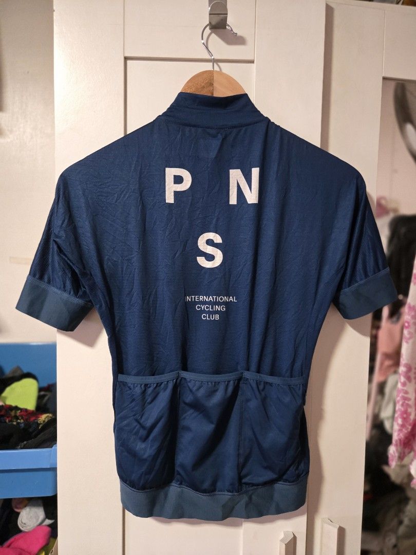 Pas Normal Studios Cycling Jersey (Category: Activewear) located in Quezon City. Submitted by ddlry (Listing ID 1422004393, Image 2). Description: - Pas Normal Studios cycling jersey - Dark blue color - Full-length zipper - Short sleeves - PNS logo on chest - "PNS INTERNATIONAL CYCLING CLUB" on back - Back pockets for storage.