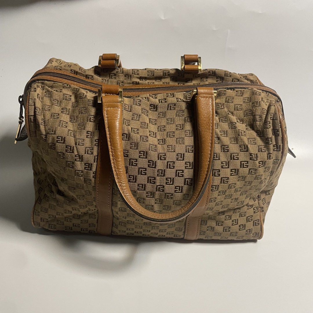 Pierre Balmain Brown Handbag (Category: Luxury Bags & Wallets) located in Cabiao. Submitted by mark_galang (Listing ID 1421952989, Image 2). Description: - Pierre Balmain handbag - Brown color with repeating logo pattern - Brown leather handles and trim - Zipper closure with Pierre Balmain tag - Metal feet on the bottom - Interior features matching logo pattern - Interior tag number: 195603.