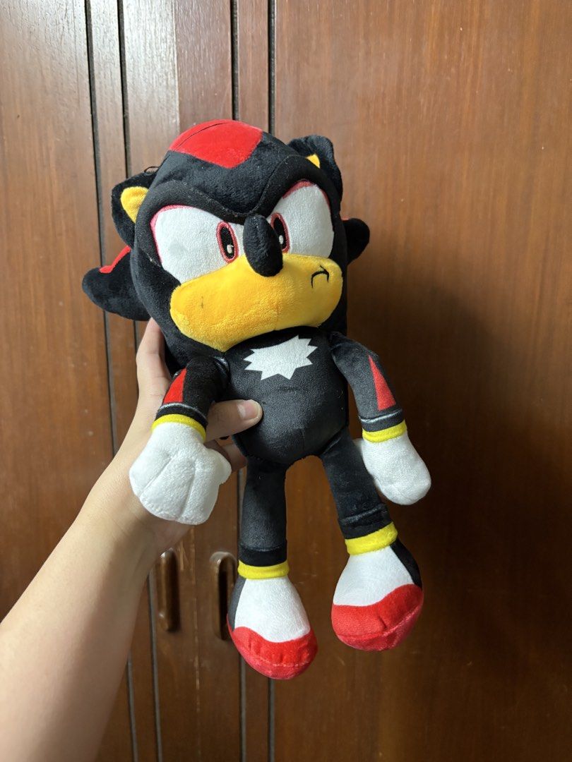 Shadow the Hedgehog Plush Toy (Category: Plushies & Soft Toys) located in San Juan City. Submitted by mksb0112 (Listing ID 1421988222, Image 1). Description: - Shadow the Hedgehog plush toy - Color scheme: Black, red, and white - Features a yellow muzzle and white gloves/shoes - Standing position - Includes star-shaped chest emblem - Soft and cuddly.