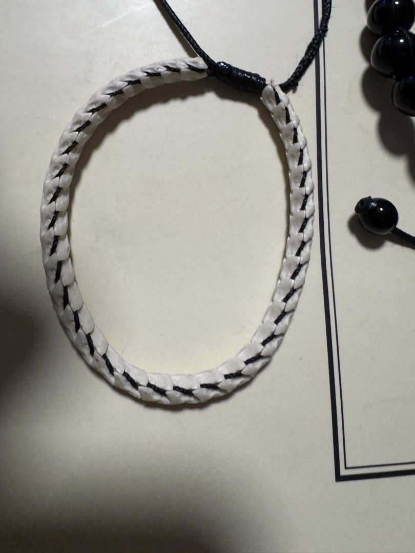Snake Bone and Black Bead Bracelets (Category: Bracelets) located in Marikina City. Submitted by luvbags40524 (Listing ID 1422012601, Image 1). Description: - Two unique bracelet designs available. - One bracelet features a bone-like woven design. - The other bracelet has black beads. - Both bracelets are adjustable with a black string. - Bone-like bracelet has a circular shape. - Black bead bracelet has a traditional design..