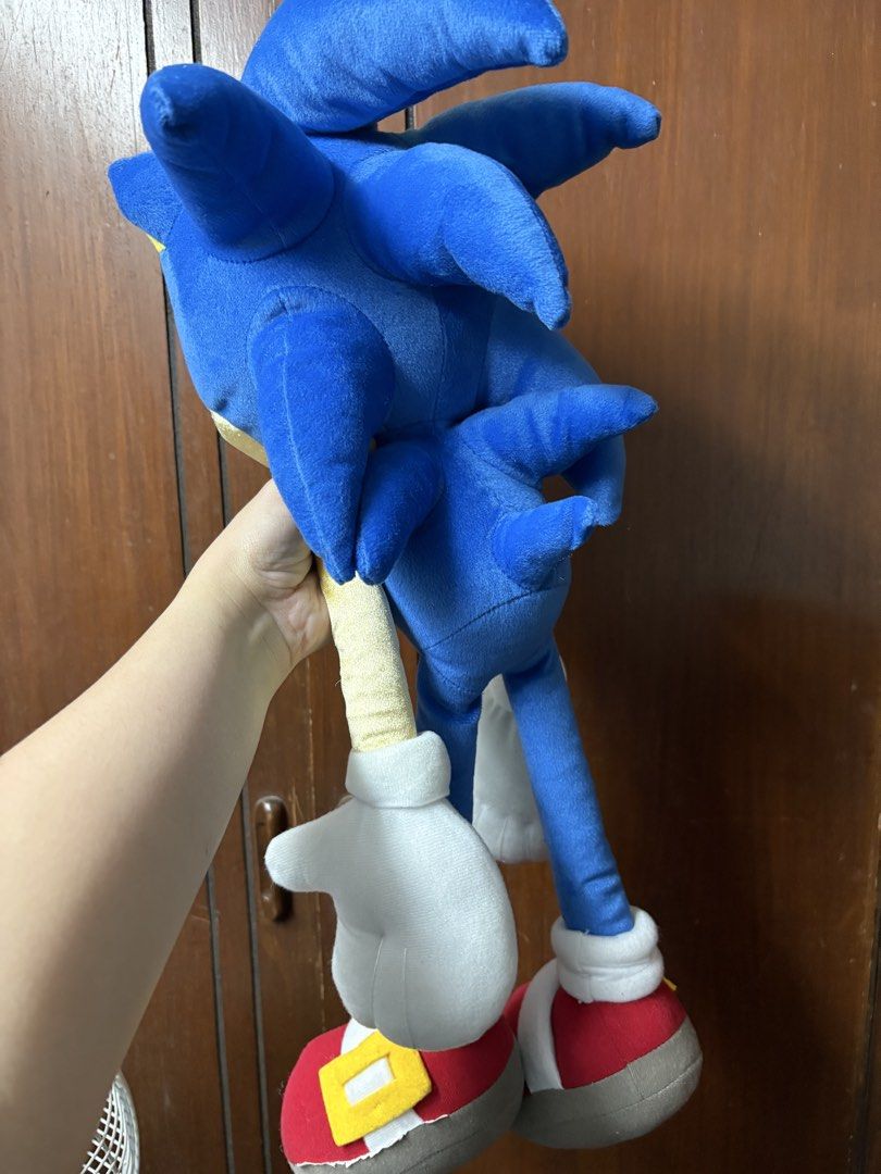 Sonic the Hedgehog Plush Toy (Category: Plushies & Soft Toys) located in San Juan City. Submitted by mksb0112 (Listing ID 1421988151, Image 2). Description: - Large Sonic the Hedgehog plush toy - Iconic blue fur - White gloves - Red shoes with yellow accents - Yellow belly - Detailed face with green eyes - Sitting position with extended arms and legs.