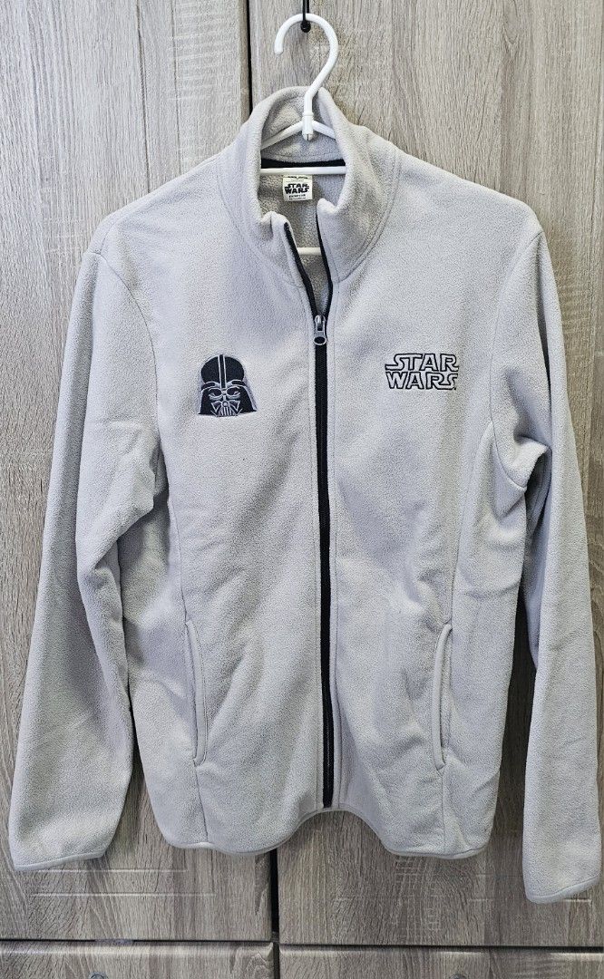 Star Wars Fleece Jacket (Category: Coats, Jackets and Outerwear) located in Marikina City. Submitted by anbierose (Listing ID 1421995054, Image 1). Description: - Star Wars fleece jacket - Darth Vader patch on left chest - Star Wars logo on right chest - Full zip closure - High collar - Light gray color - Two front pockets.