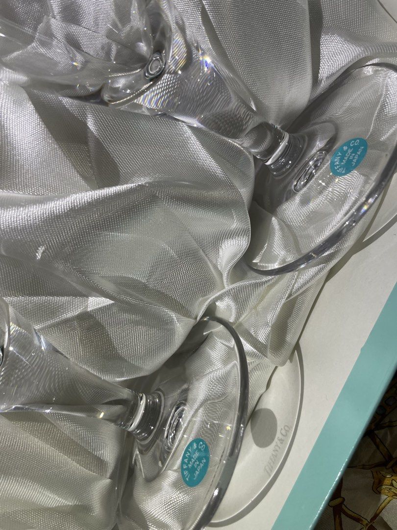 Tiffany & Co. Champagne Flutes (Category: Dinnerware & Cutlery) located in Plaridel. Submitted by collectorscamp (Listing ID 1422047048, Image 3). Description: - Set of two Tiffany & Co. champagne flutes - Elegant clear glass design with silver rims - Features the iconic Tiffany & Co. logo on the base - Comes in the original Tiffany & Co. box - Box includes a luxurious satin lining - Made in Japan.