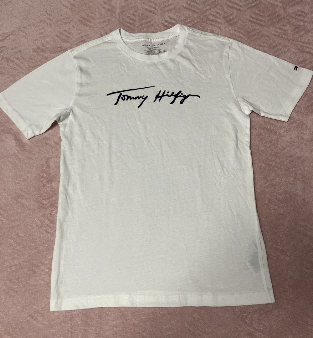 Tommy Hilfiger White T-shirt (Category: Babies & Kids Fashion) located in Paranaque City. Submitted by princessann0721 (Listing ID 1422056449, Image 1). Description: - Tommy Hilfiger T-shirt - Signature logo on front - Logo detail on sleeve - Crew neck - Short sleeves - Soft, likely cotton fabric - Perfect for everyday wear - Brand New but No tag.