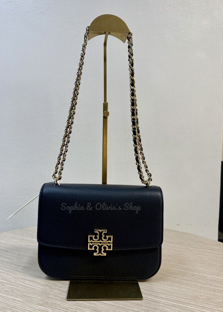 Tory Burch Britten Small Adjustable Shoulder Bag (Category: Luxury Bags & Wallets) located in Pasig City. Submitted by ellaandviashop (Listing ID 1421948860, Image 1). Description: - Tory Burch Britten Small shoulder bag - Color: Black (BLACK/001) - Gold-tone chain strap - Flap closure with Tory Burch logo - Interior zippered pocket - Textured finish - Style number: 140987 - Small size 🇵🇭 On hand PH 🆕 Brand New and Ready to Ship 📍Lalamove/LBC