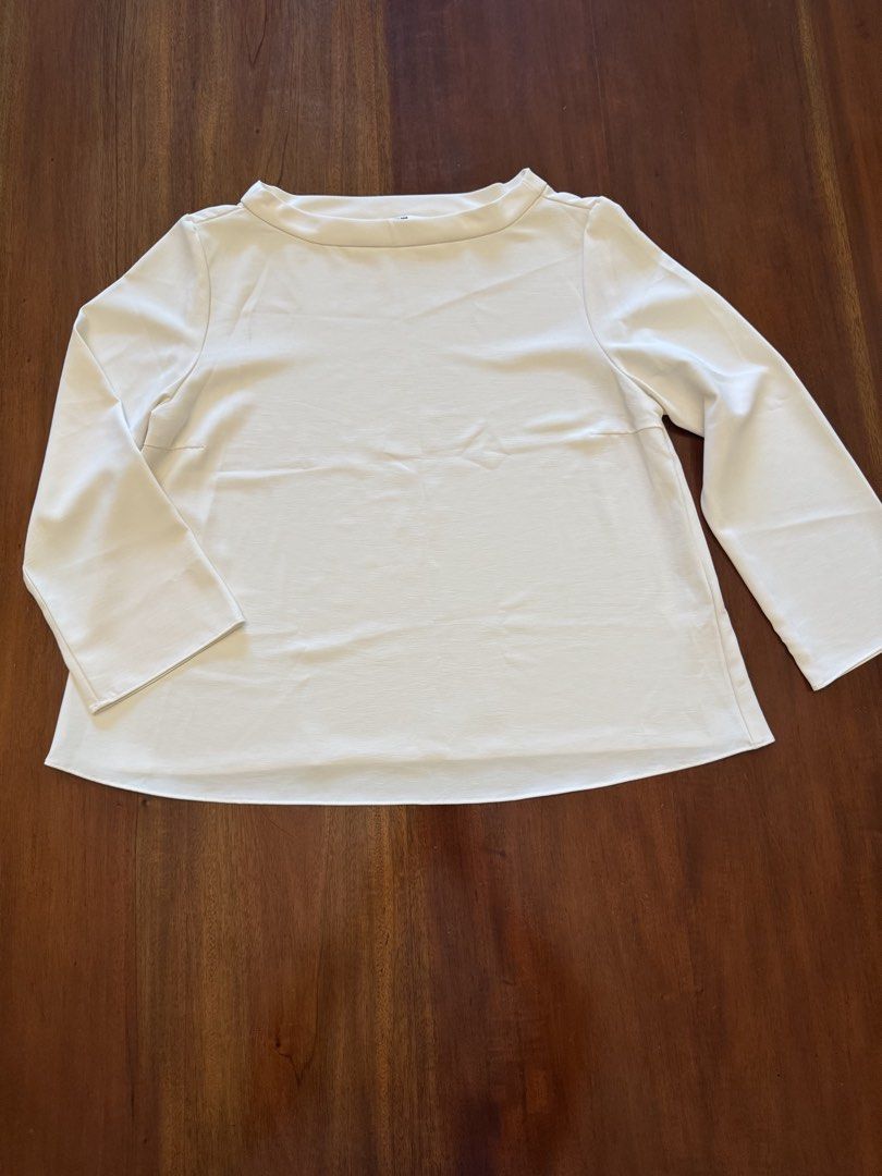 Uniqlo White Blouse - Size M (Category: Blouses) located in Mandaue City. Submitted by marginiz (Listing ID 1421956046, Image 1). Description: White blouse from Uniqlo, size M. Features a boat neck and long sleeves with flared cuffs. The blouse has a straight hemline. The length is approximately 23 inches, and the width is about 16 inches. Made in China..