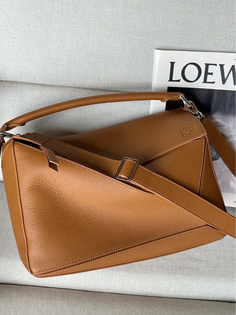 Vintage Loewe Medium Puzzle Bag - Tan (Category: Luxury Bags & Wallets) located in Quezon City. Submitted by herluxe_official (Listing ID 1422081413, Image 1). Description: - Loewe Puzzle Bag - Stunning tan color - Distinctive geometric design - Top handle and detachable shoulder strap - Silver-tone hardware - Spacious interior - Secure zipper closure - Features the Loewe logo.