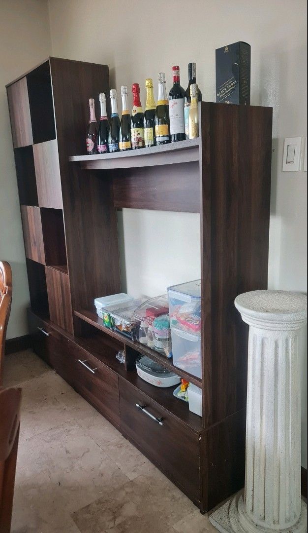 TV Rack with Cabinets, Shelves, Drawers (Category: Shelves, Cabinets & Racks) located in Quezon City. Submitted by Patrice_Shop (Listing ID 1421970446, Image 2). Description: - with chips in the laminates - Entertainment unit - Central space for TV - Multiple shelves and drawers for storage - Three bottom drawers - Dark brown laminate finish - Ideal for living room essentials.