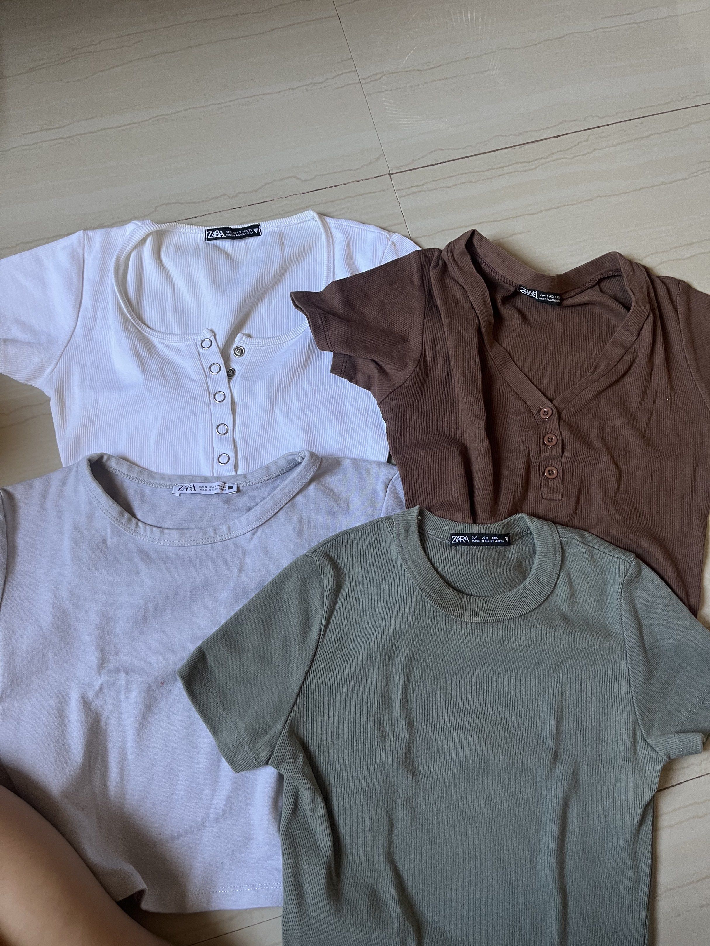 Zara Crop Tops Bundle (Category: Others Tops) located in San Pedro. Submitted by tinybubbless (Listing ID 1421955786, Image 1). Description: Set of Zara crop tops in various colors. Includes a white top with buttons, a brown V-neck top with buttons, a green crew neck top, and a light purple crew neck top. All tops appear to be made of a ribbed material. Perfect for casual wear..