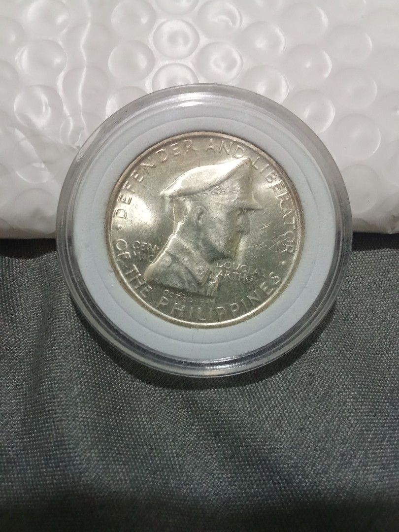 1947 Philippines One Peso Coin (Category: Currency) located in Quezon City. Submitted by mogan27 (Listing ID 1422174338, Image 1). Description: - 1947 One Peso coin from the Philippines. - Features Douglas MacArthur on one side. - Displays the Philippine coat of arms on the other. - Preserved in a protective plastic holder..