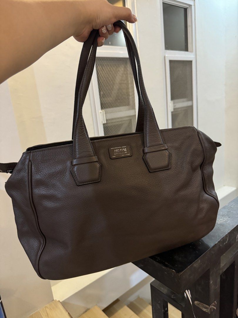 Armani Collection Brown Leather Tote Bag (Category: Luxury Bags & Wallets) located in Urdaneta. Submitted by kathleenja24136 (Listing ID 1422086298, Image 1). Description: - Armani Collection tote bag - Rich brown color - Spacious interior - Zippered pocket - Snap closure - Sturdy handles - Classic design - Light beige interior lining - Textured leather finish.