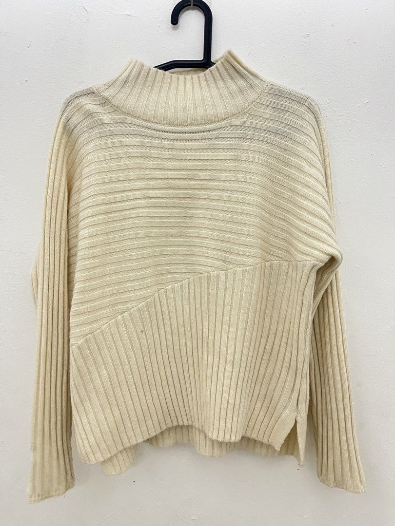 Cream Ribbed Sweater knitwear (Category: Longsleeves) located in Klang. Submitted by byzkaa (Listing ID 1422173204, Image 2). Description: - Cream-colored ribbed sweater - Mock neck design - Unique diagonal pattern on lower front - Long sleeves - Side slits - Made of soft, warm material - Suitable for cooler weather - Versatile style.
