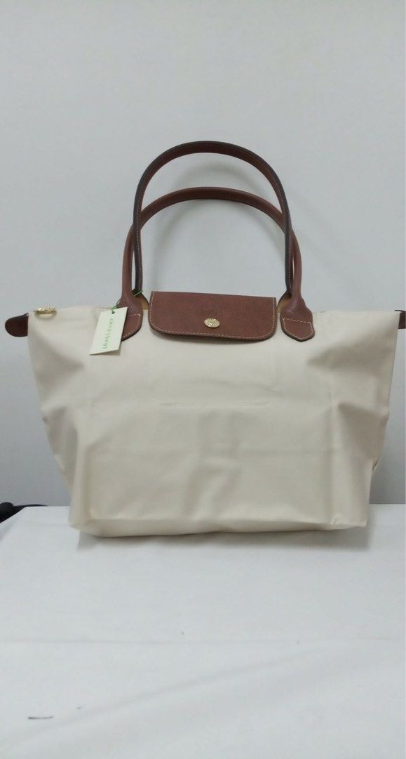 Longchamp Le Pliage Tote Bag in small (Category: Luxury Bags & Wallets) located in Quezon City. Submitted by herluxe_official (Listing ID 1422082579, Image 1). Description: - Authentic Longchamp Le Pliage tote bag - Cream nylon body - Brown leather handles and flap - Gold-tone snap closure - Includes Longchamp tag - Rectangular shape - Spacious interior - Ideal for everyday use.