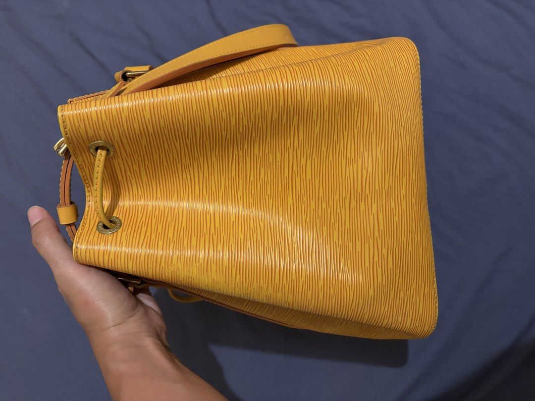 Louis Vuitton Epi Bucket Bag Yellow (Category: Luxury Bags & Wallets) located in Manila. Submitted by dmmai (Listing ID 1422189383, Image 3). Description: - Authentic Louis Vuitton Epi Bucket Bag - Vibrant yellow Epi leather - Drawstring closure - Adjustable shoulder strap - Purple fabric lining - malinis - Gold-tone hardware - Small LV logo detail - Buckle closure on strap - Provided drawstring slider (not real leather) - Personally bought in Ja