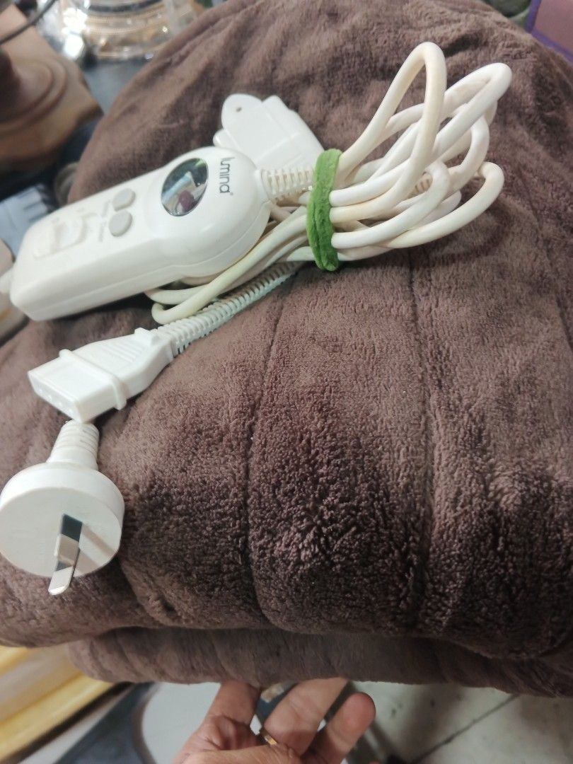 Lumina Electric Heating Pad (Category: Massage Devices) located in Caloocan City. Submitted by surplusandbnewshop (Listing ID 1422232635, Image 3). Description: Lumina electric heating pad features a brown, plush surface. It includes a control unit with temperature and timer settings. The pad has a detachable power cord and a separate control unit holder. The power plug is a standard type..