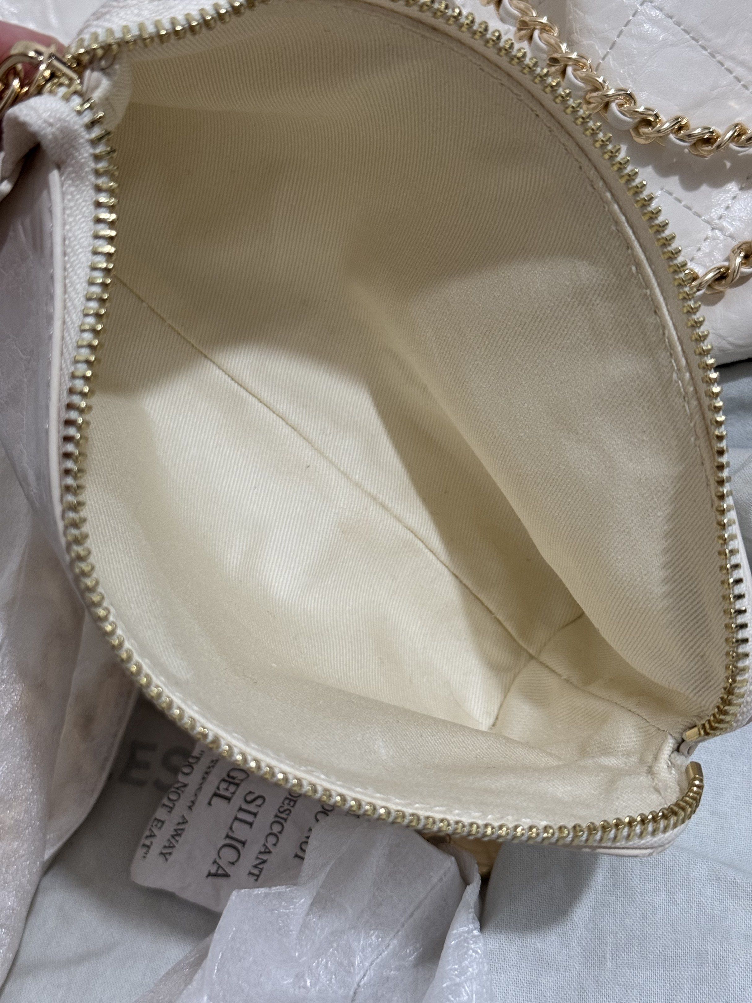 Original offwhite Charles & Keith Quilted Chain Bag Set (Category: Tote Bags) located in Bacoor. Submitted by everything_etc. (Listing ID 1422206059, Image 3). Description: - Charles & Keith handbag set - Cream color - Quilted design - Gold-tone chain straps - Includes main handbag and smaller pouch - Fabric lining with brand label inside main bag - Comes with dust bag - Detachable strap included.