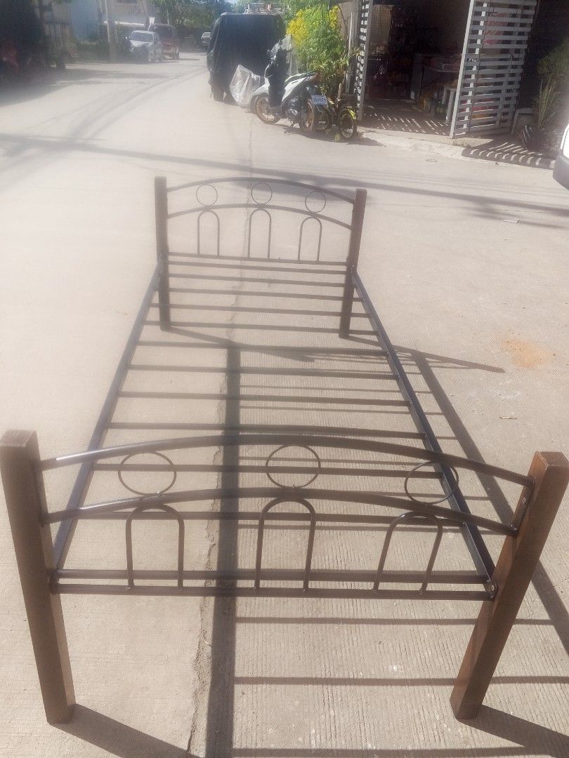 Single Bed Frame with Metal and Wood (Category: Bed Frames & Mattresses) located in Rodriguez. Submitted by amara0914 (Listing ID 1422114622, Image 1). Description: Single bed frame with a metal frame and wooden posts. The frame has a decorative design on the headboard and footboard. The width of the frame is approximately 38 inches. The wooden posts are approximately 29 inches tall. The bed frame is suitable for a single-sized mattress..