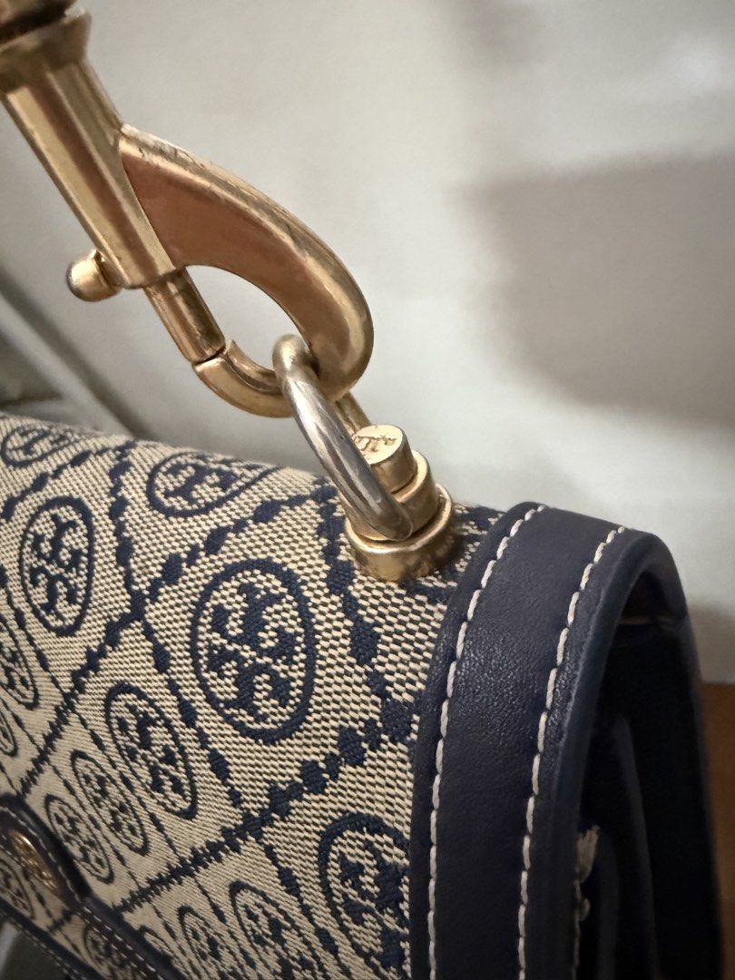 Tory Burch Crossbody Bag (Category: Luxury Bags & Wallets) located in Quezon City. Submitted by enidatfits (Listing ID 1422149327, Image 3). Description: - Tory Burch crossbody bag - Signature logo pattern - Navy blue color - Adjustable strap - Gold-tone hardware - Flap closure with logo detail - Lined interior Check photos for actual condition.