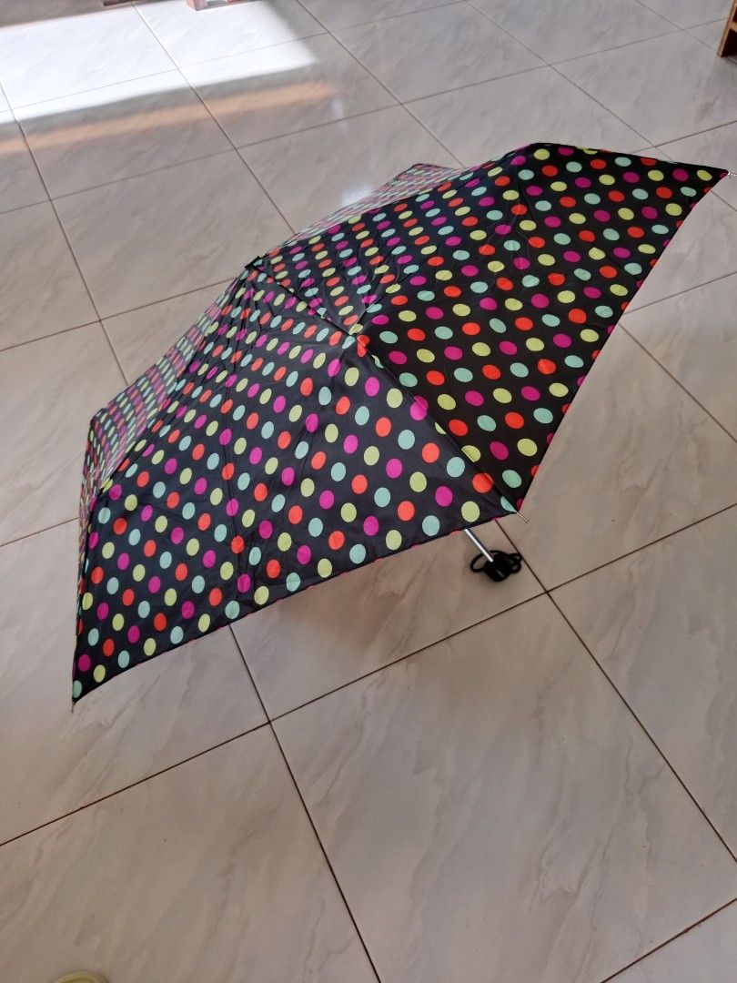 Totes Polka Dot Umbrella (Category: Umbrellas) located in Polangui. Submitted by cornerbags_shoes (Listing ID 1422121771, Image 1). Description: Totes umbrella features a colorful polka dot pattern on a black background. It is a compact, foldable umbrella. The umbrella is made of 100% polyester. It has a black handle with a wrist strap. The umbrella is made in China..
