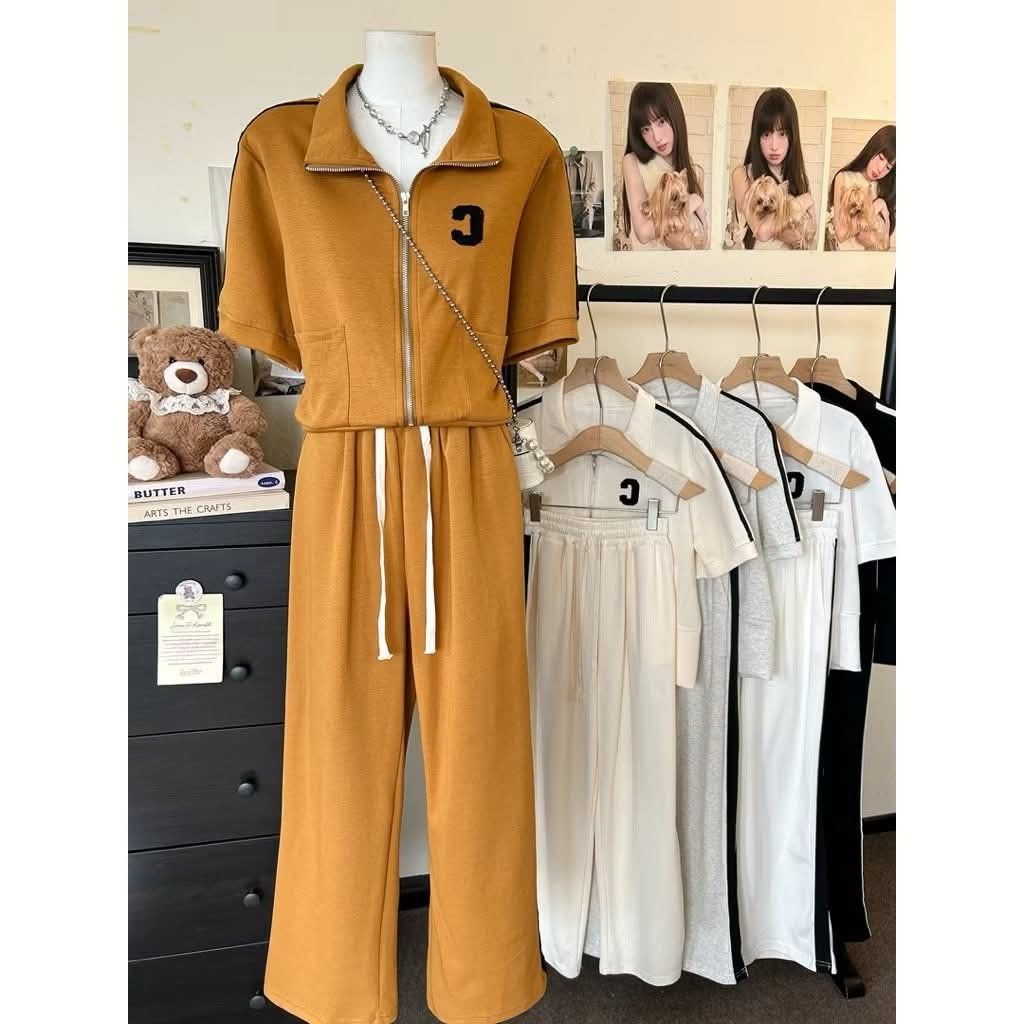 Tracksuit Set with Letter C (Category: Sets & Coordinates) located in Manila. Submitted by raredeer-4deb4e (Listing ID 1422104535, Image 1). Description: - Stylish tracksuit set - Collared zip-up top with short sleeves and "C" detail - Wide-leg pants with drawstring waist - Available colors: mustard, white, grey, black - Perfect for casual wear.