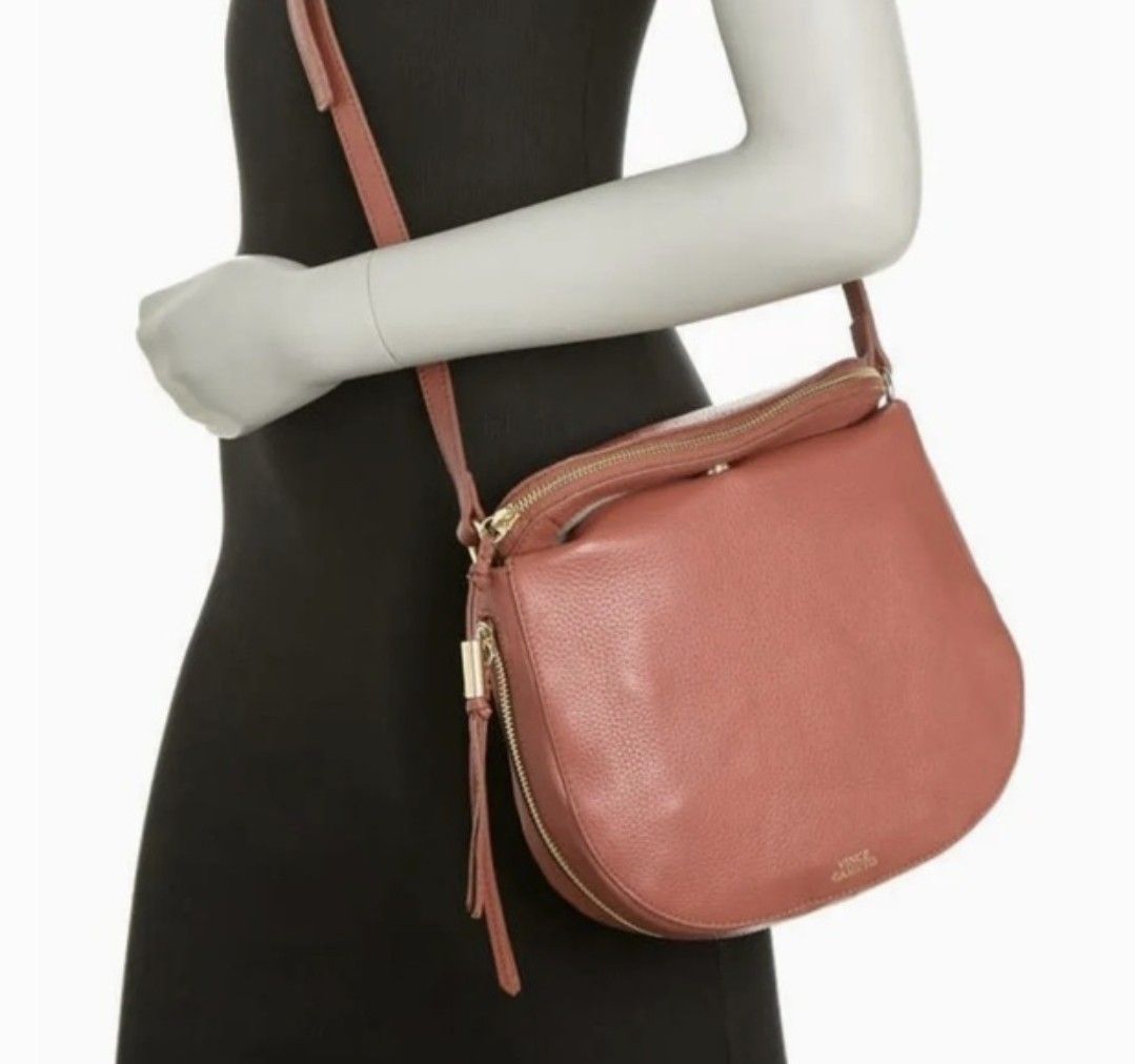 Vince Camuto Crossbody Bag (Category: Cross-body Bags) located in Imus. Submitted by my8th (Listing ID 1422150297, Image 1). Description: Crossbody bag features a beautiful reddish-brown color. It has a zippered main compartment and an additional zippered pocket on the front. The bag includes a long strap for shoulder or crossbody wear. The interior has a fabric lining and a small pocket. The Vince Camuto logo is visible on the exterior..