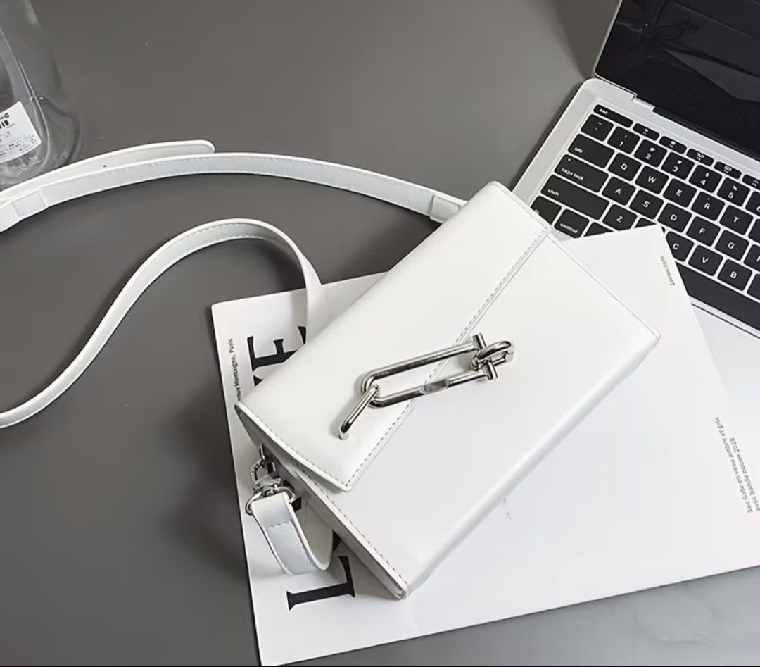 White Crossbody Bag with Silver Chain (Category: Cross-body Bags) located in Quezon City. Submitted by pjrosetase (Listing ID 1422137231, Image 2). Description: - White crossbody bag - Rectangular shape with flap closure - Silver chain detail - Detachable and adjustable shoulder strap - Smooth, leather-like material - Clean, minimalist design - Ideal for everyday or special events.