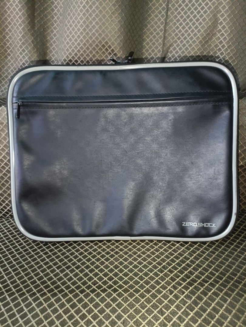 Zero Shock Laptop Sleeve (Category: Laptop Bags & Sleeves) located in San Pedro. Submitted by elevens_online_thrift_shop (Listing ID 1422107218, Image 2). Description: Zero Shock laptop sleeve features a black exterior with a white trim and a zipper closure. The interior is padded for added protection. It has a front pocket for accessories. The sleeve is designed to protect your laptop from shocks and impacts. The Zero Shock logo is visible on th