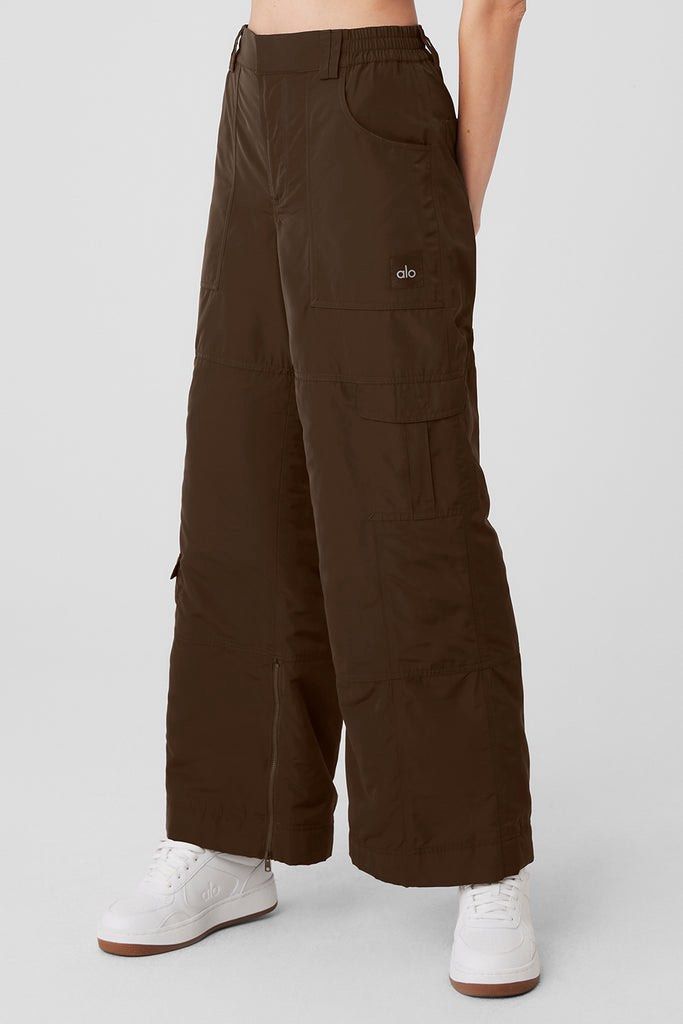 Alo Yoga Cargo Pants - Brown (Category: Activewear) located in Singapore. Submitted by haruxoneday (Listing ID 1422349599, Image 2). Description: - Alo Yoga high waisted ski moto pants - Size M (US8-10) - Espresso Brown color - Wide-leg fit - Multiple pockets - Ankle zippers for adjustable fit - Suitable for casual wear and light activities Worn once - however the waist sizing is too large for me. I re-purchased in size S. RTP: SGD220 Open to tra