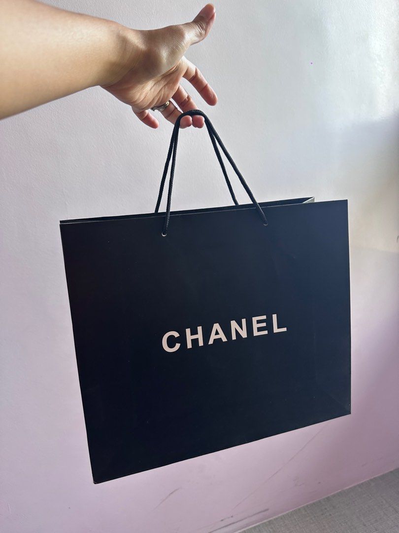 Chanel Paper Shopping Bag (Category: Luxury Bags & Wallets) located in Paranaque City. Submitted by mumziella (Listing ID 1422271348, Image 1). Description: - Authentic Chanel shopping bag -230PHP EACH - Features the iconic Chanel logo - Color: Black bag with white logo - Includes black rope handles - Size: Approximately 23cm x 23cm - Perfect for gifting or collecting.