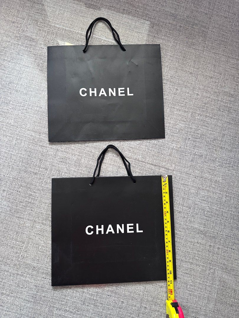 Chanel Paper Shopping Bag (Category: Luxury Bags & Wallets) located in Paranaque City. Submitted by mumziella (Listing ID 1422271348, Image 2). Description: - Authentic Chanel shopping bag -230PHP EACH - Features the iconic Chanel logo - Color: Black bag with white logo - Includes black rope handles - Size: Approximately 23cm x 23cm - Perfect for gifting or collecting.