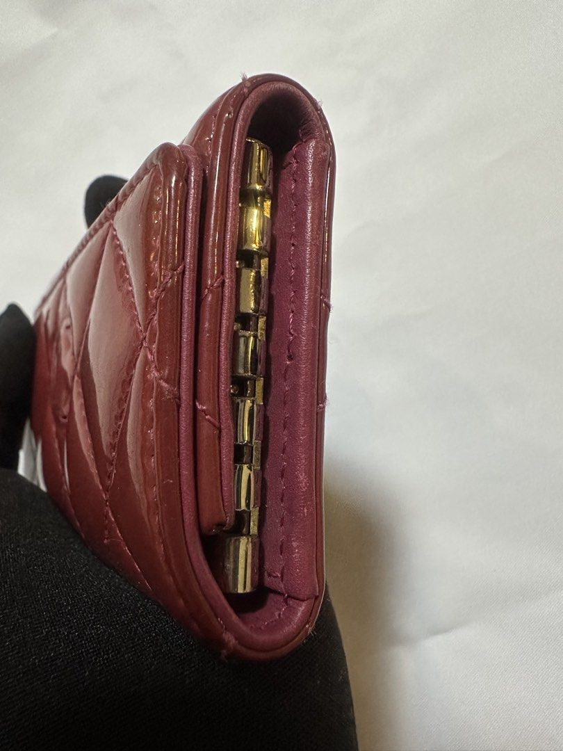 Chanel Quilted Key Holder (Category: Luxury Bags & Wallets) located in San Pablo. Submitted by donaya_luxe (Listing ID 1422253030, Image 3). Description: - Authentic Chanel key holder - Quilted design - Exterior: Burgundy patent leather - Interior: Pink leather - Includes key hooks - Features Chanel logo - Made in Spain - Snap closure Missing Chanel metal logo in the front.