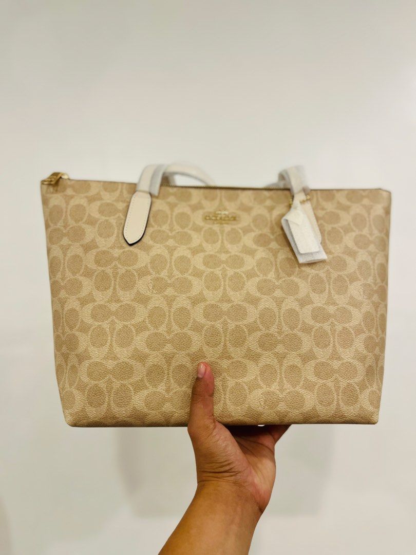 Coach Signature Tote Bag (Category: Luxury Bags & Wallets) located in Manila. Submitted by luxwalletbags (Listing ID 1422252534, Image 1). Description: Coach tote bag in signature print. Beige with cream trim and handles. Features zip closure and dual handles. Includes hang tag..