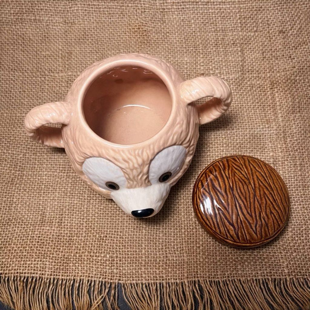 Disney Duffy Bear Ceramic 3D Mug with Cover (Category: Food Organization & Storage) located in Bulacan. Submitted by ceramicscubby (Listing ID 1422374050, Image 3). Description: Size: 2.3 D x 3.75 H in. ❗️ALL PRICES ARE MARKED DOWN❗️ - Adorable Duffy Bear ceramic mug. - Features a detailed bear face design. - Includes a lid with a wooden-like texture. - Has two handles. - Marked "Disney" and "Made in Thailand". - Ideal for collectors and Disney f