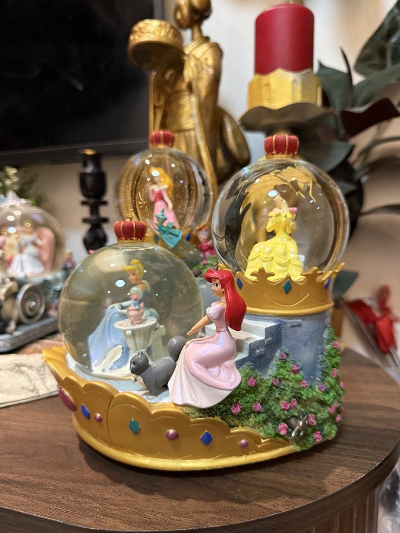 Disney Princess Musical Snow Globe (Category: Figurines & Statues) located in Manila. Submitted by blueseamarketing (Listing ID 1422352740, Image 3). Description: - Disney Princess snow globe - Features Cinderella, Ariel, Belle, Aurora, and Snow White - Crown-shaped base - Musical function - Castle-like structure - Detailed and colorful figures - Charming collectible item.