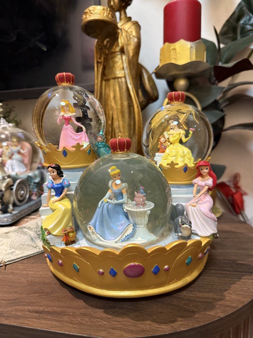 Disney Princess Musical Snow Globe (Category: Figurines & Statues) located in Manila. Submitted by blueseamarketing (Listing ID 1422352740, Image 1). Description: - Disney Princess snow globe - Features Cinderella, Ariel, Belle, Aurora, and Snow White - Crown-shaped base - Musical function - Castle-like structure - Detailed and colorful figures - Charming collectible item.