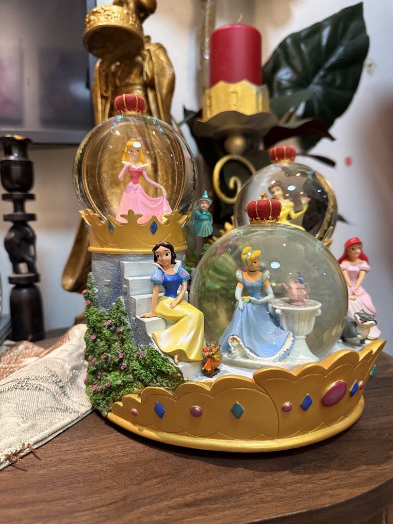 Disney Princess Musical Snow Globe (Category: Figurines & Statues) located in Manila. Submitted by blueseamarketing (Listing ID 1422352740, Image 2). Description: - Disney Princess snow globe - Features Cinderella, Ariel, Belle, Aurora, and Snow White - Crown-shaped base - Musical function - Castle-like structure - Detailed and colorful figures - Charming collectible item.